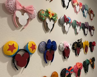 Minnie Ears Wall HolderOur girls have so many ears and just added more on our last trip. We were displaying them on our Disney Ear Frames… but now we have too many. This Mickey silhouette Minnie Ears Wall Holder